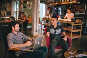 Team meeting with men smiling over laptop